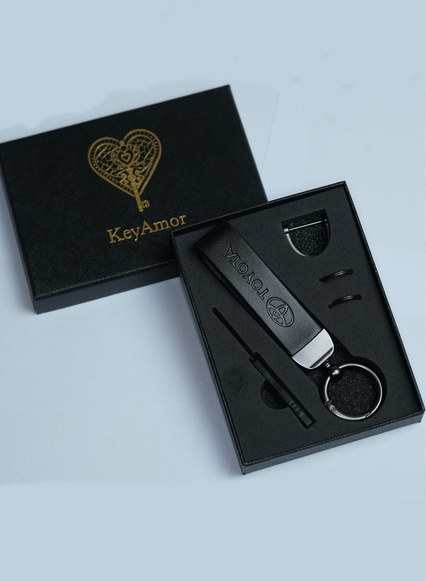 Elegant black metal and leather keychain with TOYOTA logo featuring 3 key rings perfect as a fancy gift or car accessory designed in sleek black for a modern look offers 360 degree rotation for convenience suitable for both men and women and comes in a fancy gift box